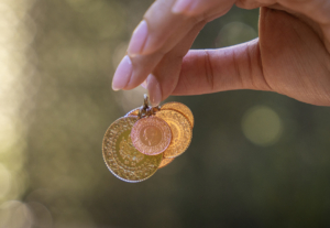 Young woman holding Turkish Gold coins in hand
