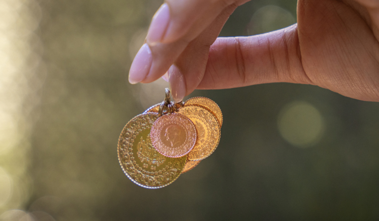 Young woman holding Turkish Gold coins in hand